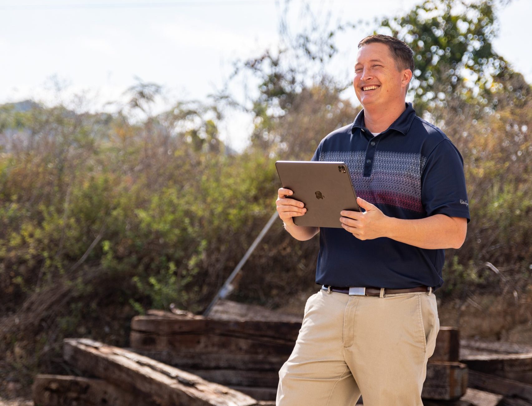 Man in the field with an iPad using crewOS for industrial construction field crew