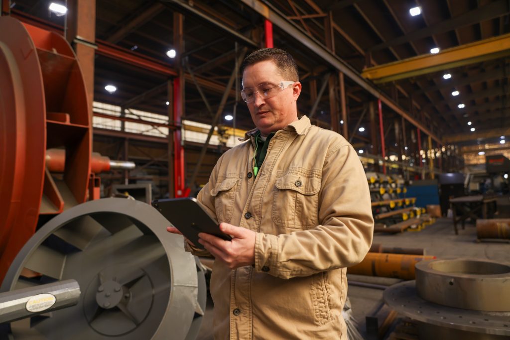 Man using crewOS industrial field service app on his iPad at an industrial plant