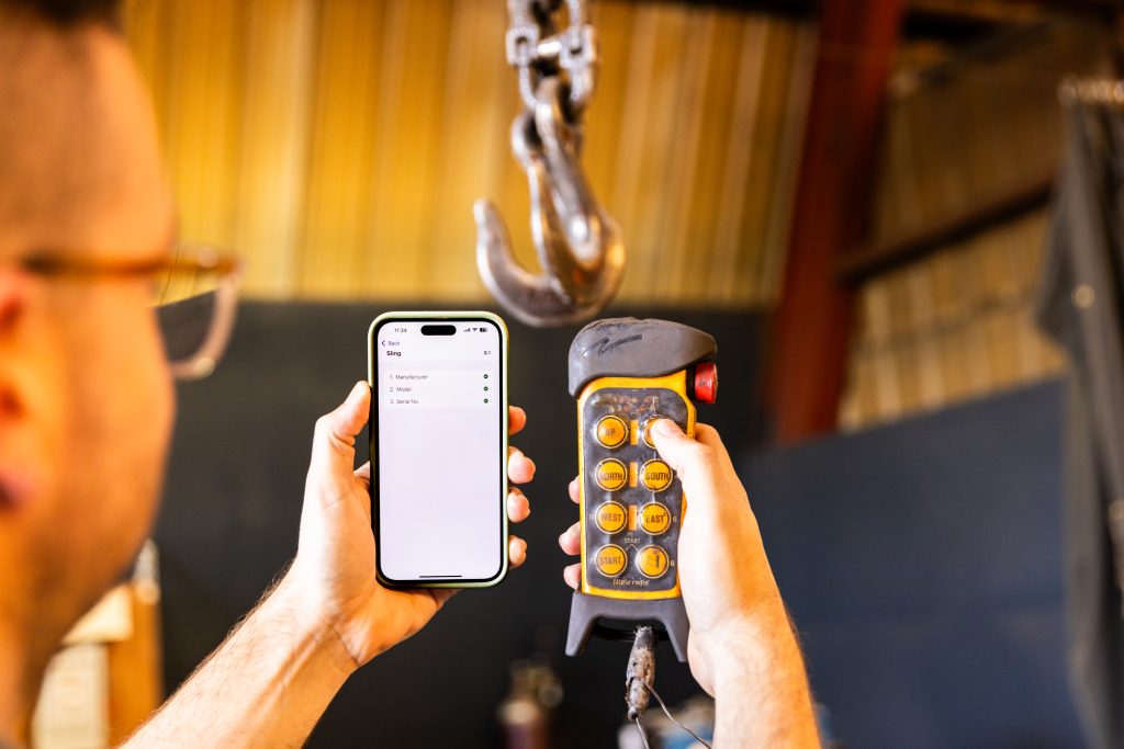 Industrial field service technician completing a digital inspection on a mobile device