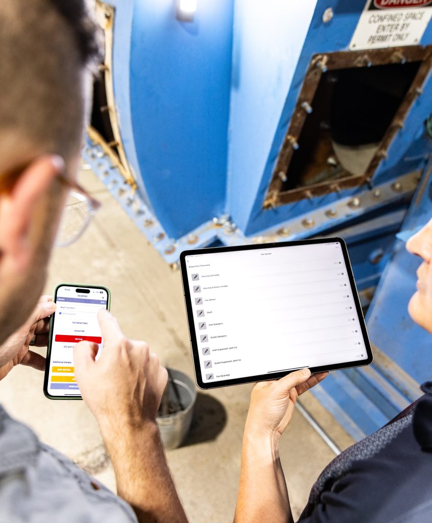 Industrial field service technician completing a digital inspection on a mobile device